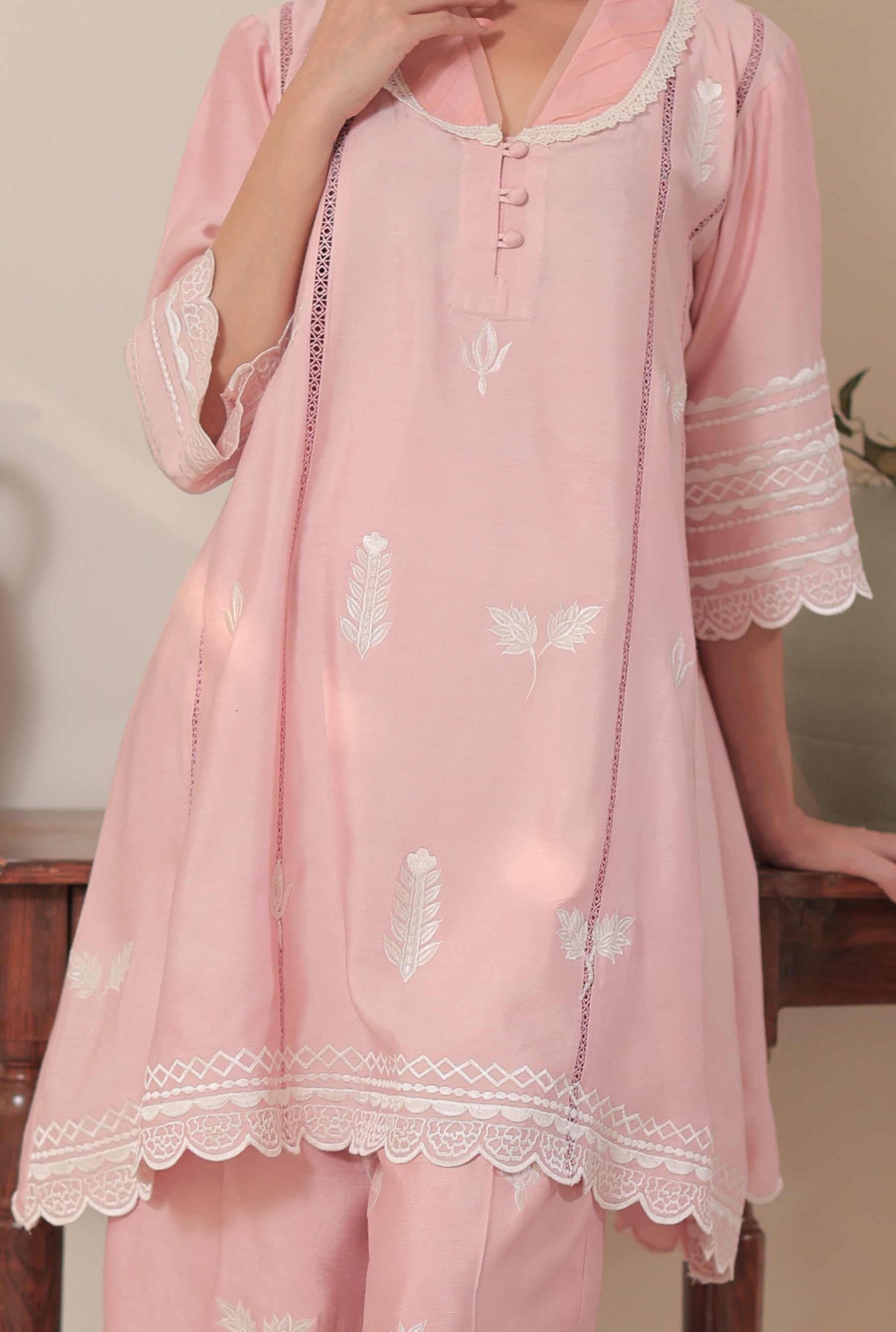 Model wearing Rosy Whisper outfit in blush pink khadi silk with white embroidery and lace-detailed sleeves and pants