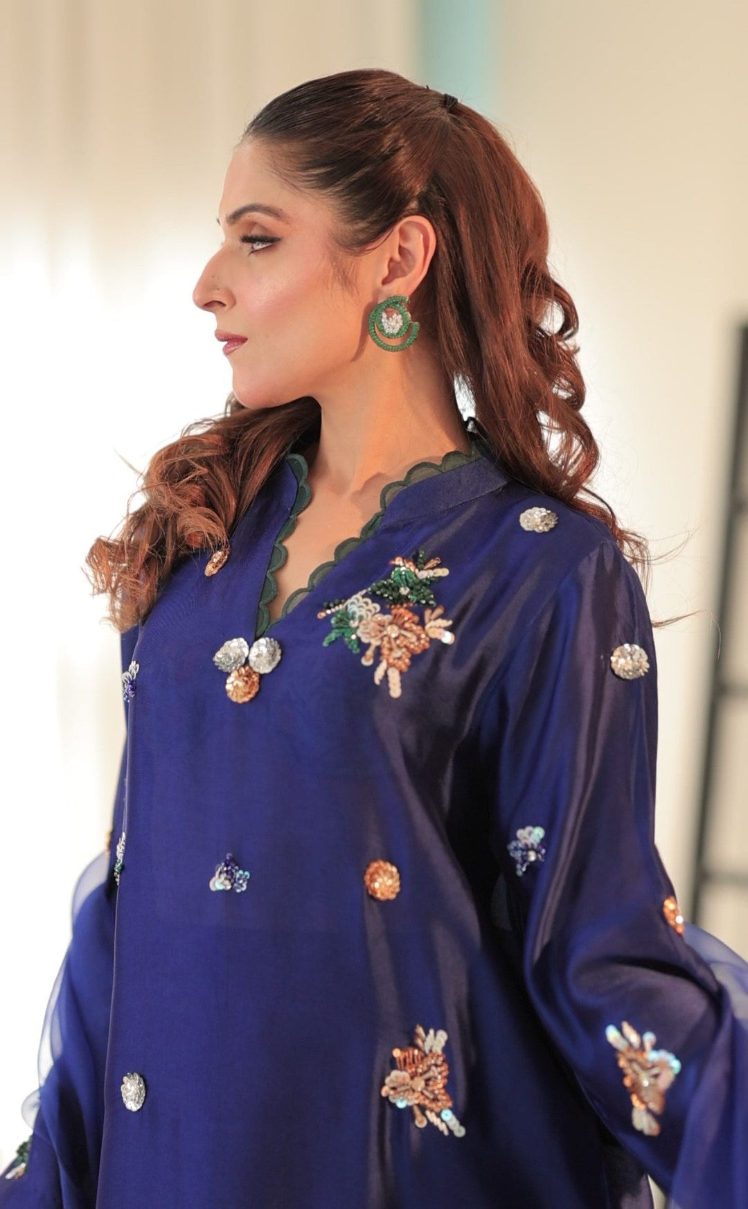 Model wearing cobalt blue Sheesha silk outfit with hand embroidery, scalloped hem, and organza dupatta finished with silk border and gota work