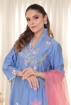 Elegant denim blue khadi silk ensemble with pastel floral hand embroidery and soft pink organza dupatta for festive or formal occasions