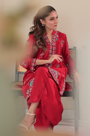 Model wearing Chillie 2-piece Sheesha silk outfit in bold red with turquoise and maroon embroidery, paired with lace-detailed pants