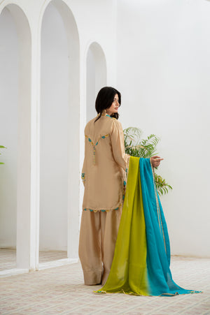 Woman holding a colorful scarf in a white architectural setting